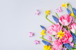 Bouquet of beautiful spring flowers on pastel table top view. Greeting card for International Women Day. Flat lay.