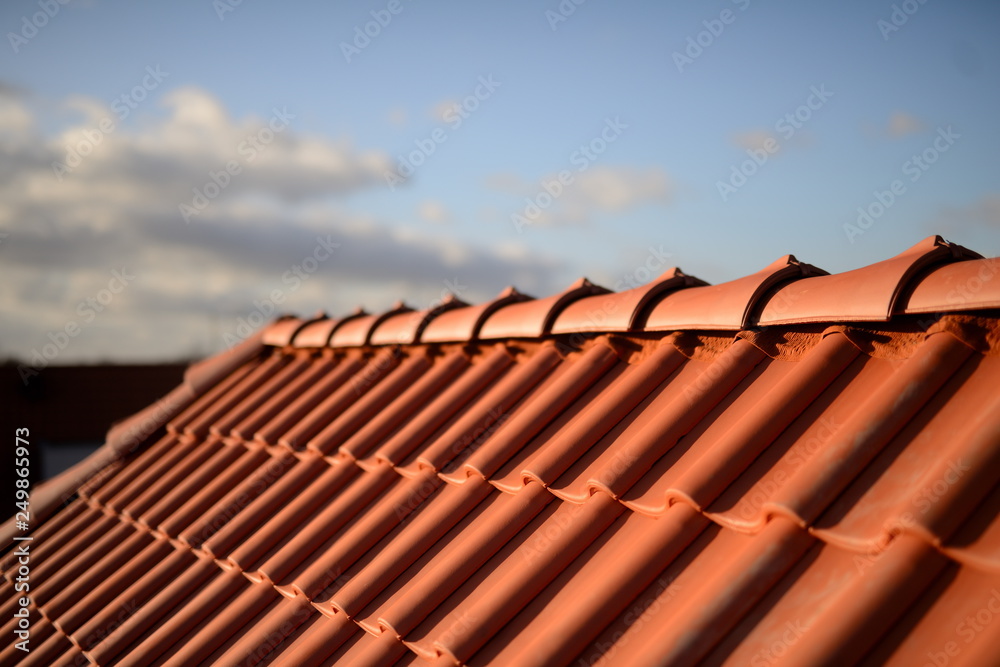 Dächer vom Dachdecker mit roten Dachziegeln. Pfannen auf Stadt Haus Neubau mit Abendrot Himmel im Hintergrund. - obrazy, fototapety, plakaty 