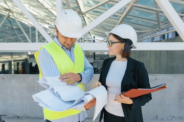 Woman engineer and man builder at construction site. Building, development, teamwork and people concept