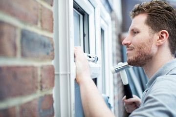 Construction Worker Installing New Windows In House