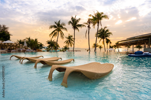 Fotografía luxury swimming pool on sea view and chair in hotel resort with sunrise time