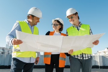 Team of builders engineer architect on the roof of construction site. Building, development, teamwork and people concept