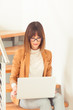 © alipko - Beautiful woman designer freelancer in eyeglasses wearing casual using laptop in white office