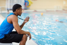 Side View Portrait Of Handsome African-American Fitness Coach Working In Swimming Pool, Copy Space