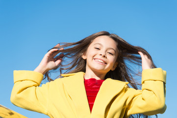 Happy day. Kid girl long hair enjoy walk sunny day blue sky background. Girl carefree childhood walk. Charming little stylish fashionable girl. Feeling free and happy. Little child enjoy sunny walk