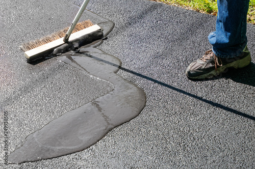 Fotografía Spreading asphalt resealer onto driveway for maintenance