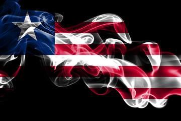 Wall Mural - National flag of Liberia made from colored smoke isolated on black background. Abstract silky wave background.