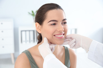 Dermatologist examining patient's face in clinic. Skin cancer checkup