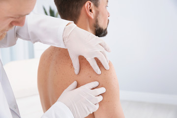 Wall Mural - Dermatologist examining patient's birthmark in clinic