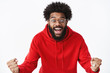 © Cookie Studio - Studio shot of surprised and thrilled african american guy clenching fists in joy and amazement popping eyes and smiling excited reacting to unexpected great news, winning, achieving prize