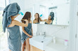 © Alena Ozerova - Mom brushing hair to her daughter in hotel bathroom