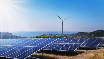 concept clean energy power in nature. solar panel and wind turbine on hill with sunshine