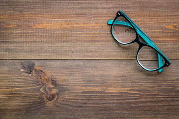 Canvas Print - Stylish glasses with transparent lenses on dark wooden background top view space for text