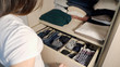 © lenblr - The drawer with underwear in the closet. Girl organizing clothes in wardrobe, close up.