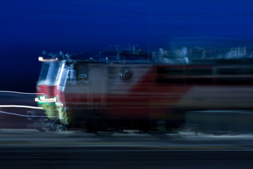 Wall Mural - Train in motion on the station at night, long exposure photo.