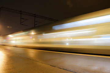 Wall Mural - Train in motion on the station at night, long exposure photo.