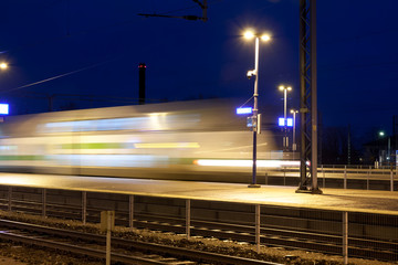 Wall Mural - Train in motion on the station at night, long exposure photo.