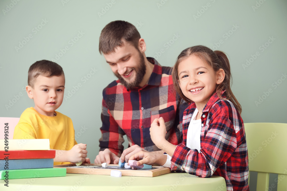 Young father with his children drawing at home