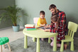 © Pixel-Shot - Young father with his children drawing at home