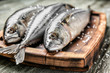 Wooden board with tasty raw mackerel fish on table