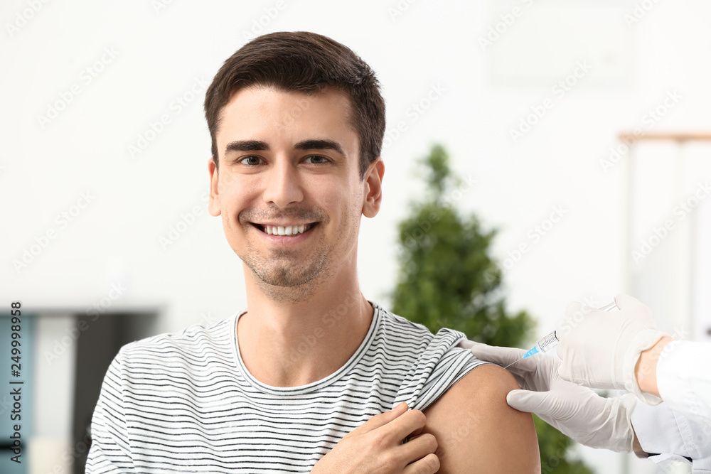 Doctor vaccinating male patient in clinic