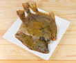 Raw flounders on square dish on a wooden table