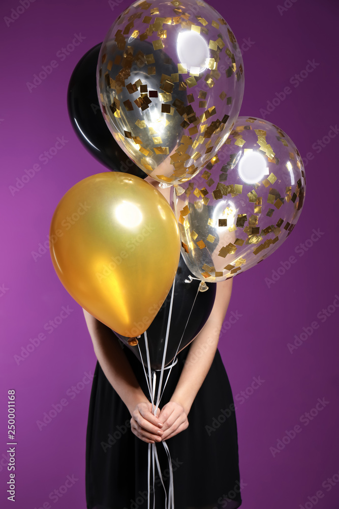 Beautiful young woman with balloons on color background