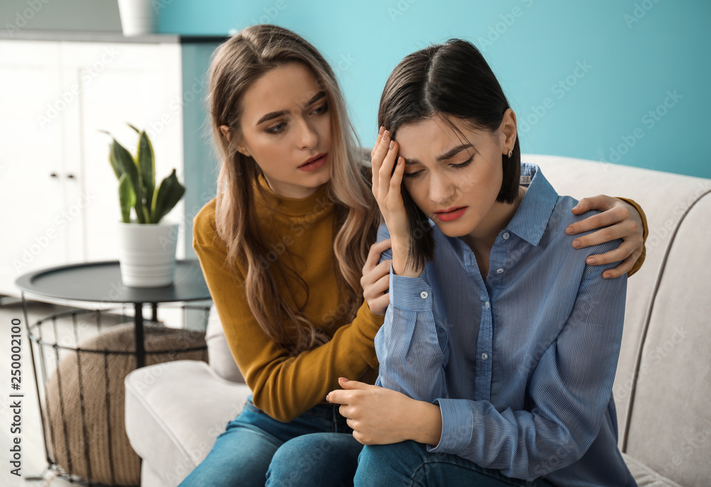 Young woman calming her friend indoors
