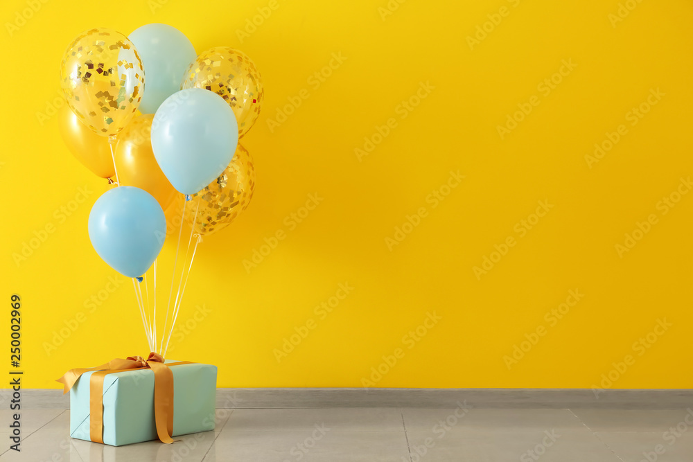 Birthday balloons with gift box in room