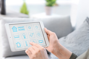 Young woman using application of smart home automation