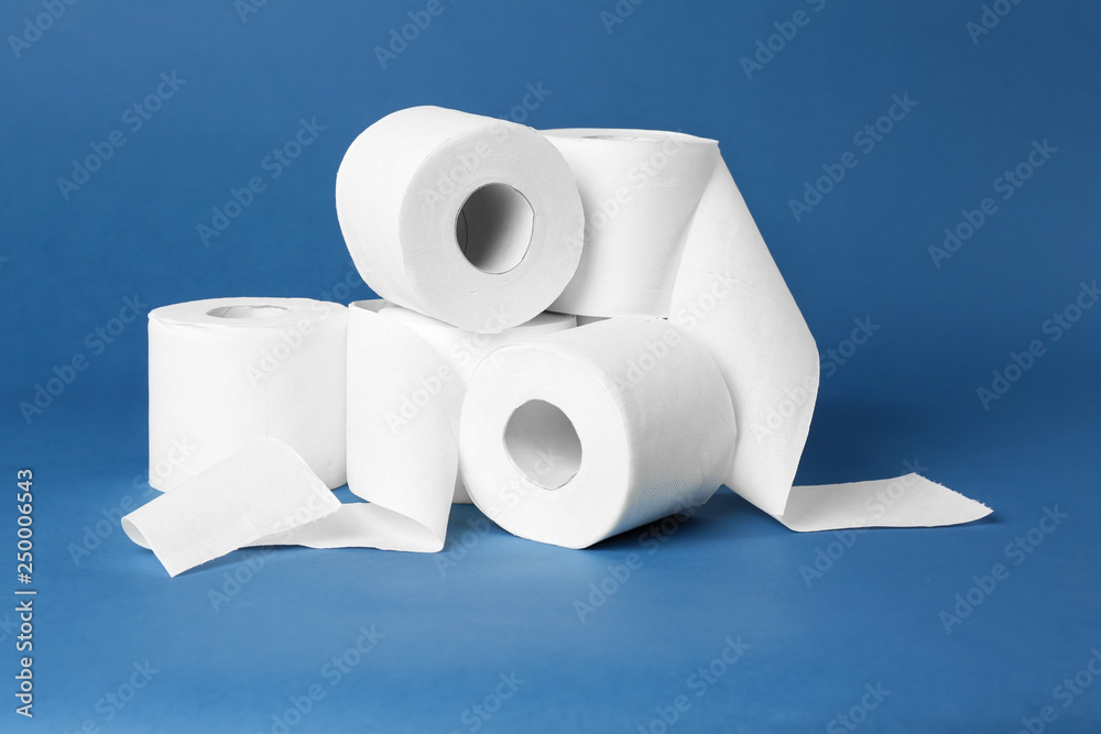 Rolls of toilet paper on color background