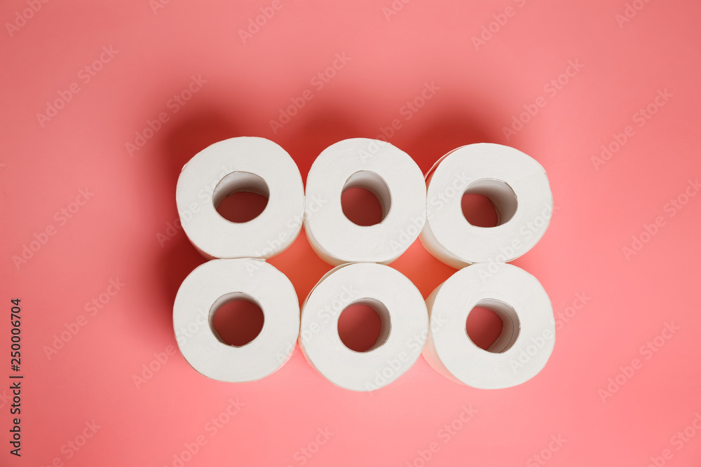 Rolls of toilet paper on color background