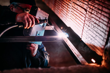 Wall Mural - Industrial Worker laborer at the construction site, welding steel structure