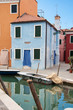 Painted house near a quiet canal in Burano, Italy