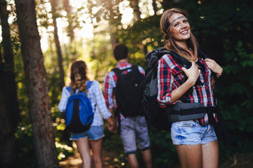 Wall Mural - beautiful woman and friends hiking in forest