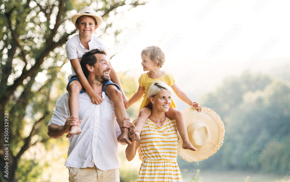 Young family with small children in sunny summer nature. - obrazy, fototapety, plakaty 