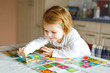 © Irina Schmidt - Adorable cute toddler girl playing picture card game at home or nursery. Happy healthy child training memory, thinking. Development step and education of kid.