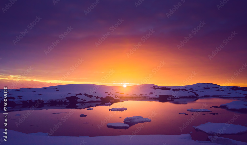 Colorful cloudy sky over the Antarctica shoreline Bay. Overwhelming sunset view. The snow covered shore next to the cold ocean. Ideal background for the collages in blue, purple and orange tints. - obrazy, fototapety, plakaty 