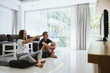 © Alena Ozerova - Teenagers watching tv while sitting on couch