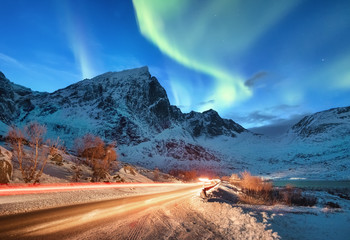 aurora borealis on the lofoten islands, norway. road traffic and blur car light. green northern ligh
