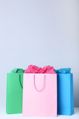 Wall Mural - Colorful paper shopping bags on grey background