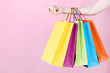 © 5second - Female hand holding colorful shopping bags on pink background