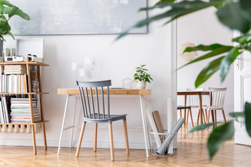 Wall Mural - Modern scandinavian home decor of interior with creative wooden desk, bamboo bookstand with accessories, books and plants  Open space and living room. Brown wooden parquet and stylish carpet.