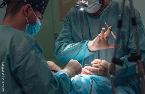 Fotografía Surgeon and his assistant performing cosmetic surgery on nose