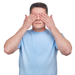 Man with blue t-shirt covering his eyes two hands