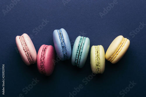 Colorful macarons on dark blue background. Top view. Tableau sur Toile