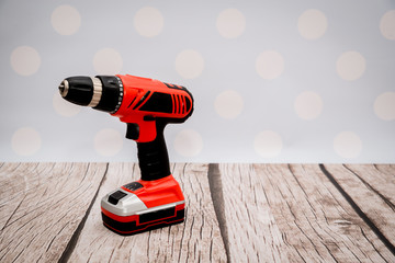 Poster - A red screwdriver on a wooden floor. Screwdriver and drill ready for use at home. The concept of renovation work at home, screwing the screws to the wall.