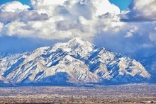 Winter Panoramic View Of Snow Capped Wasatch Front Rocky Mountains, Great Salt Lake Valley And Cloudscape From The Bacchus Highway. Utah, USA.