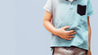 A boy dressed in a blue T-shirt catches his stomach. Concept of medicine and health, stomach ache. Stomach problems in children, indigestion, abdominal diseases in children.