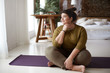 Young woman sitting on yoga mat